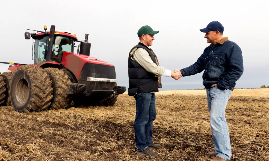 Produtor rural e engenheiro agrônomo se cumprimentando no campo